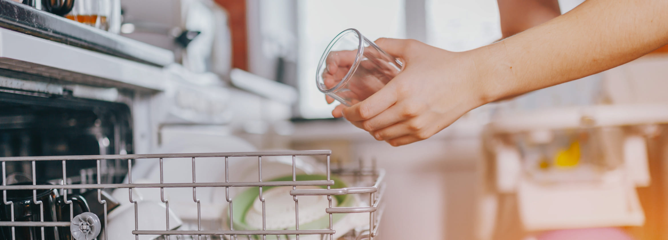 Женщина загружает посудомоечную машину